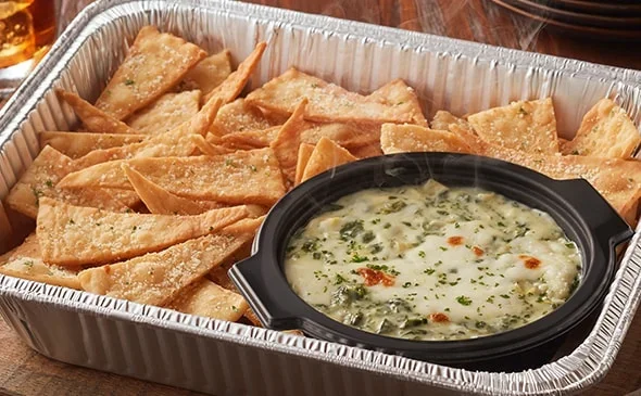 Cater your event with Spinach-Artichoke Dip and flatbread crisps, which serves 4-6 people. - Olive Garden Catering Menu